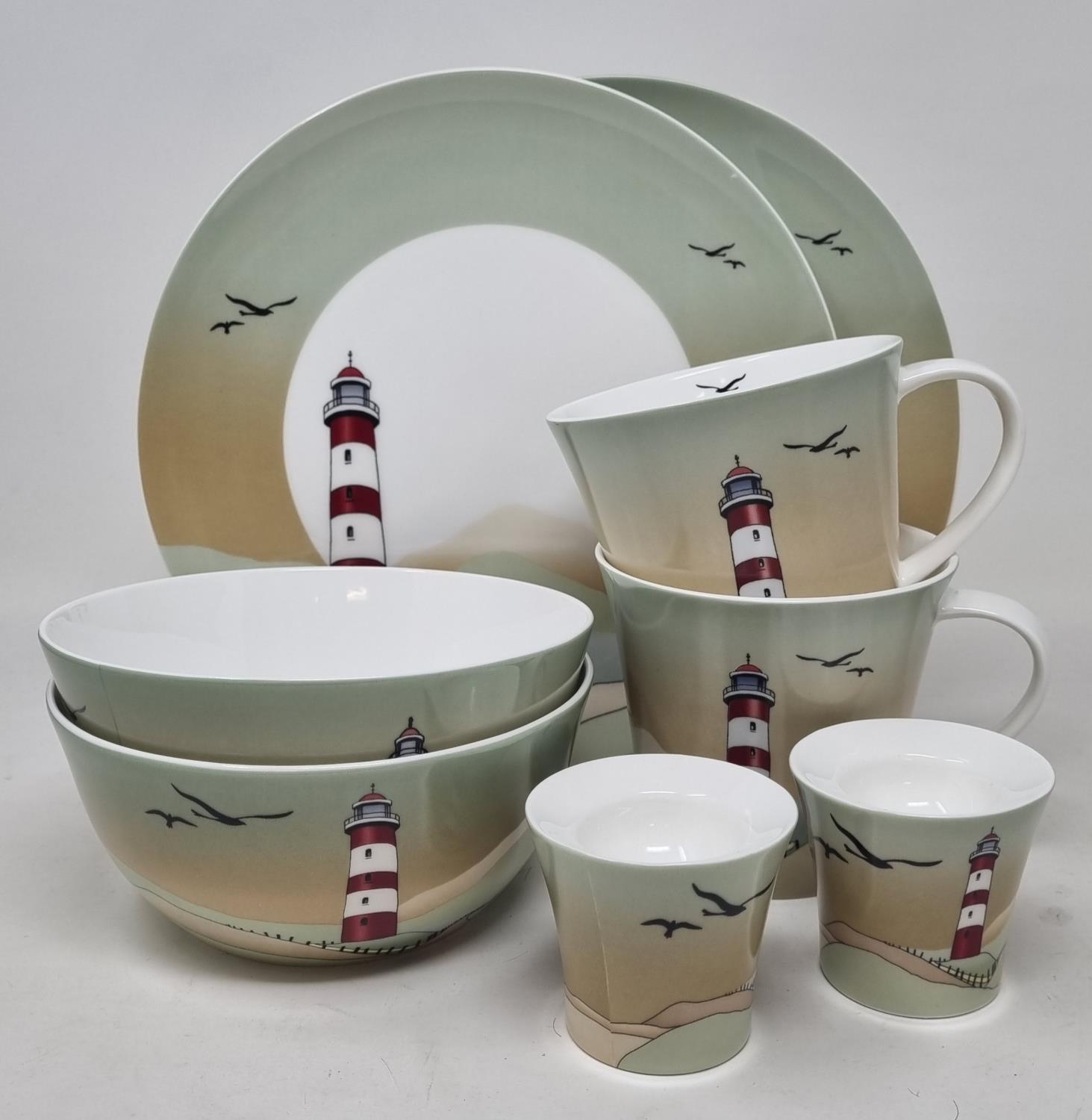 Ein Set aus Geschirr mit verschiedenen Tassen, Schalen und Tellern, verziert mit einem Leuchtturm und Vögeln.