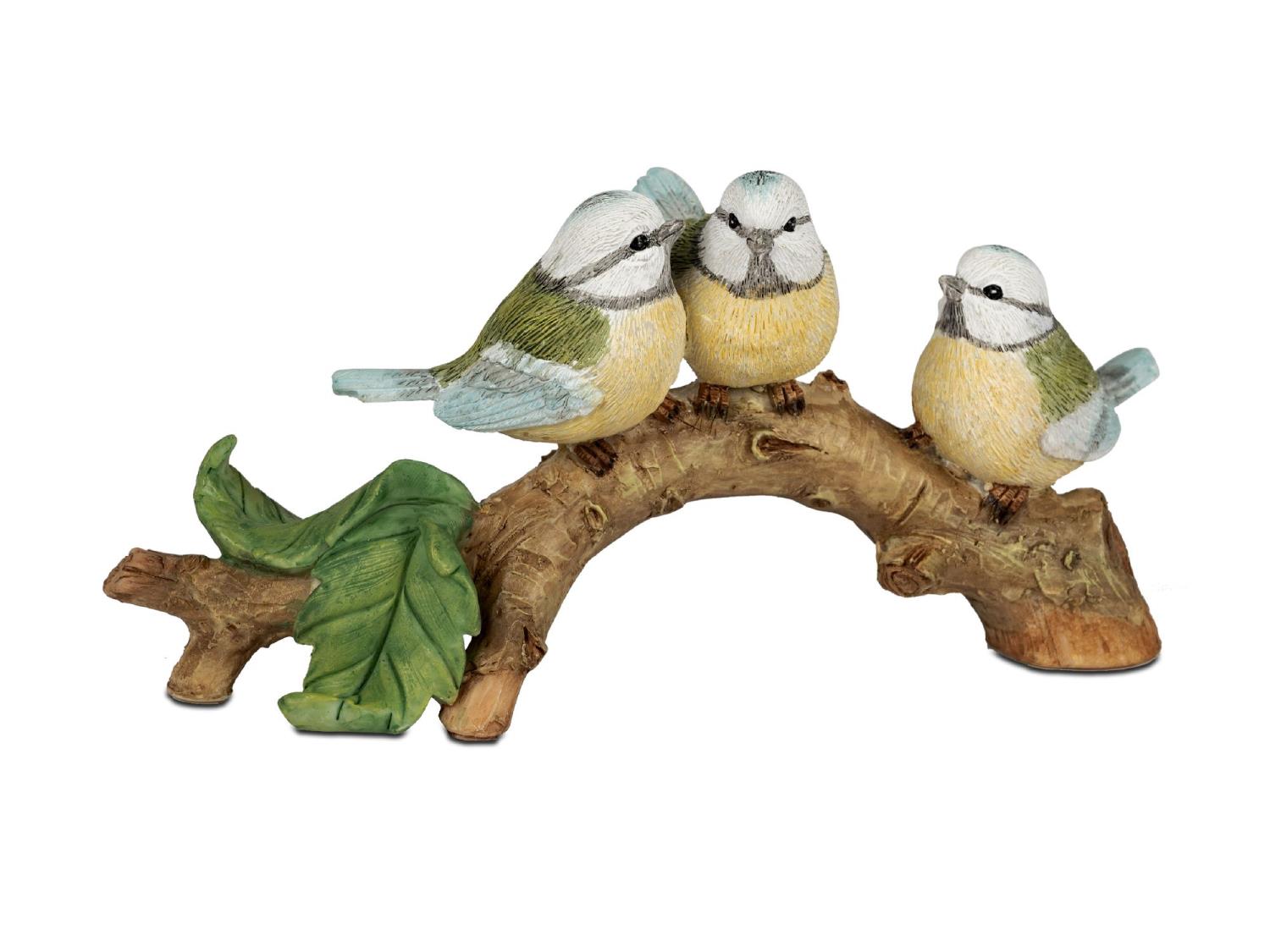 Drei kleine Vögel aus Keramik sitzen auf einem Ast, umgeben von einem Blatt. Die Vögel sind in sanften Farben gestaltet.
