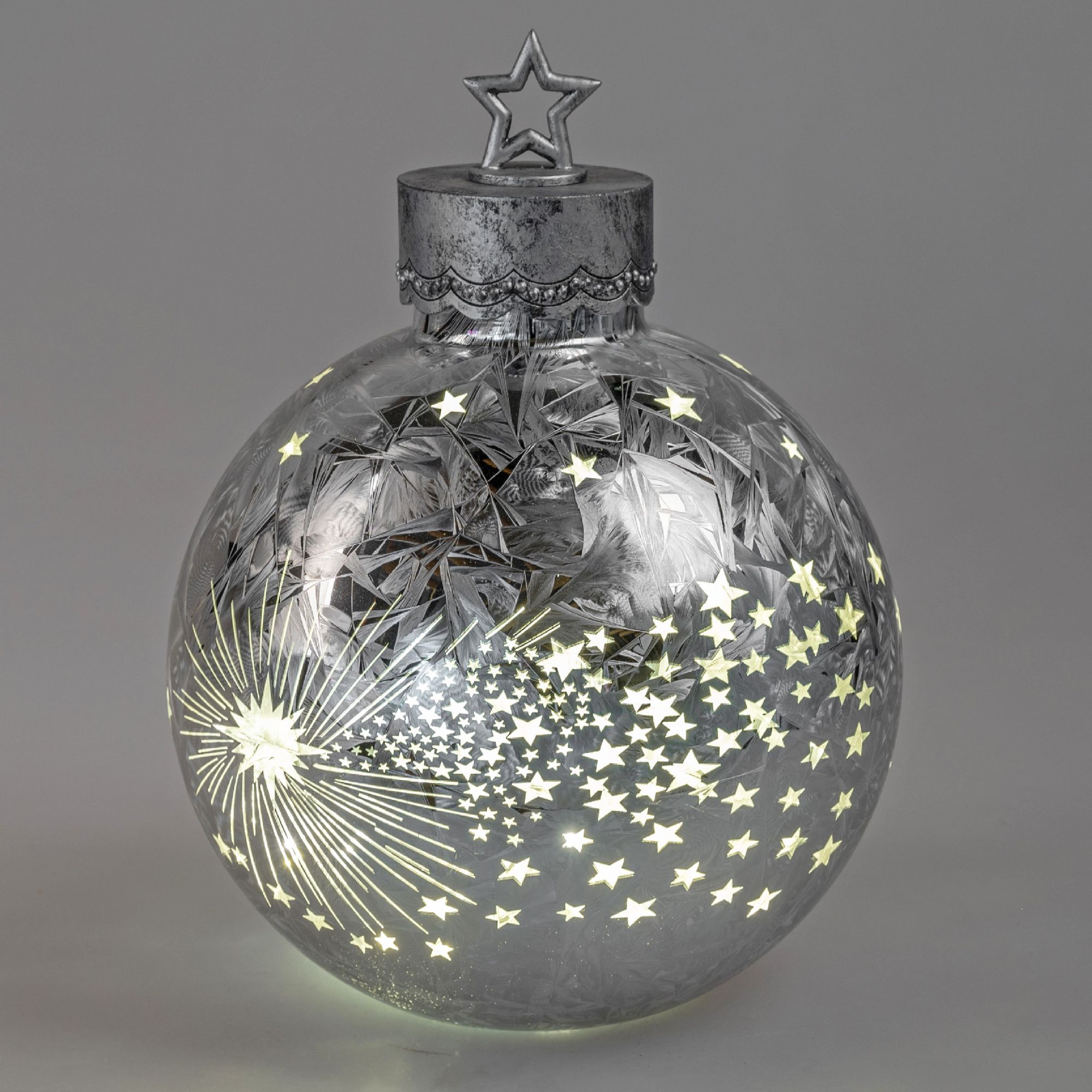 Glasige Weihnachtskugel mit Sternen- und Schneeflockenmuster, oben mit einem Sternenaufsatz. Beleuch