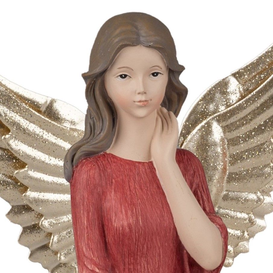 Eine Figur eines Engels mit langen, braunen Haaren und goldenen Flügeln, gekleidet in ein rotes Klei