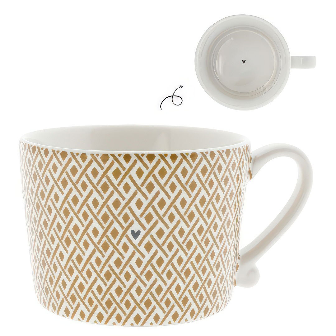 Eine weiße Tasse mit goldfarbenem, geometrischem Muster und einem kleinen Herz in der Mitte. Die Unterseite ist ebenfalls sichtbar.