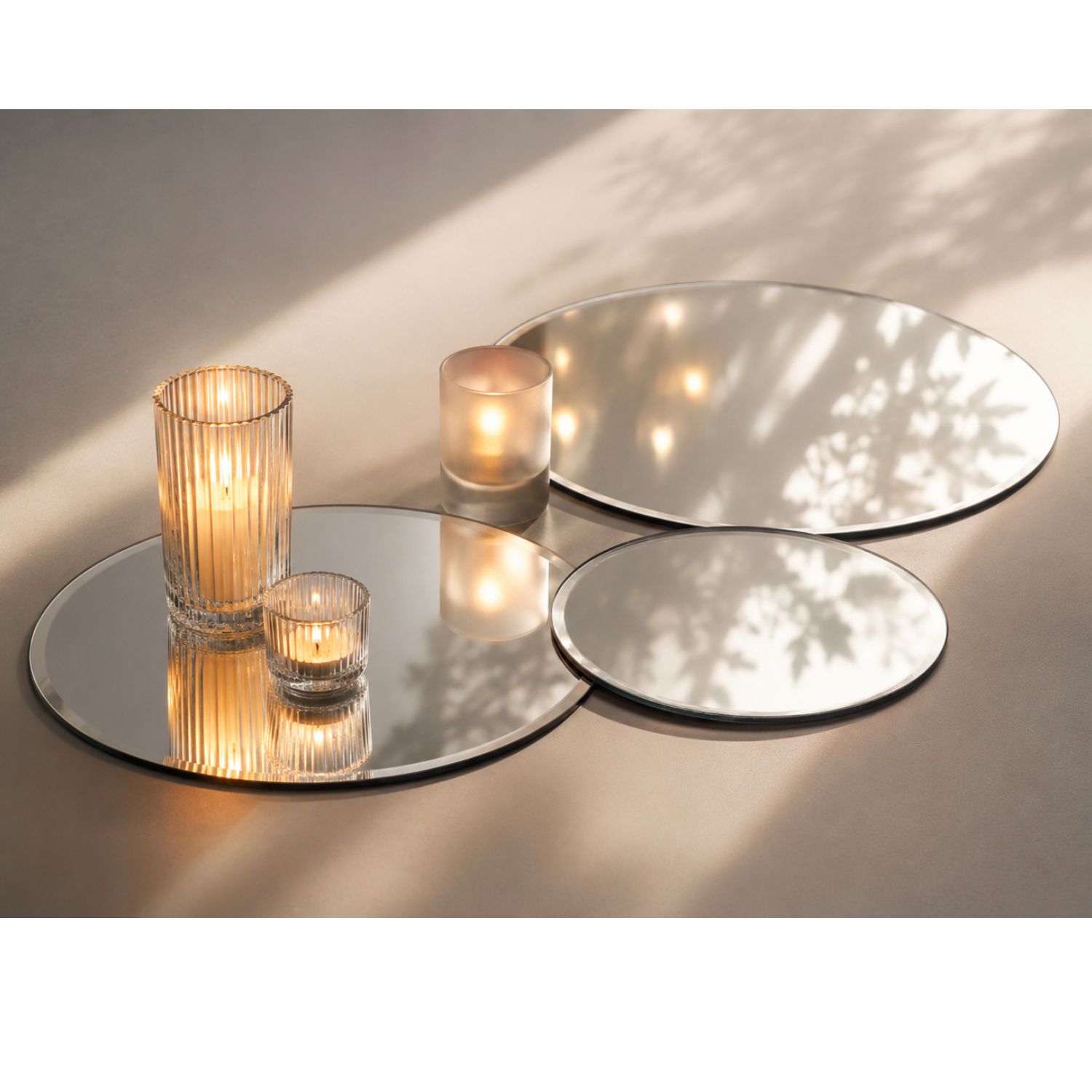 Kerzen in Glasgefäßen auf runden Spiegelplatten, Lichtreflexe und Blätterschatten