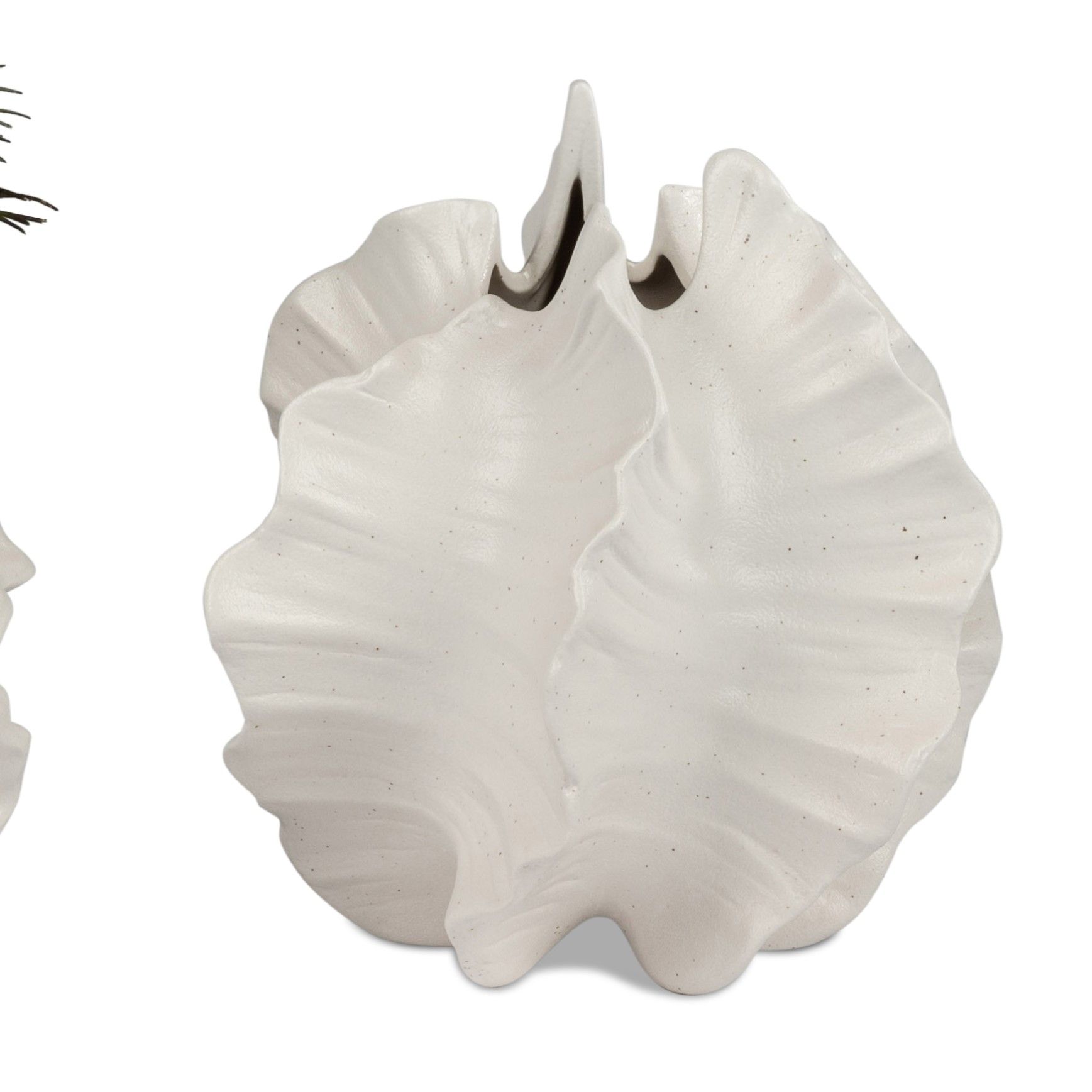 Zwei asymmetrische, weiße Keramikobjekte mit wellenförmigen Kanten, die an Blätter erinnern.