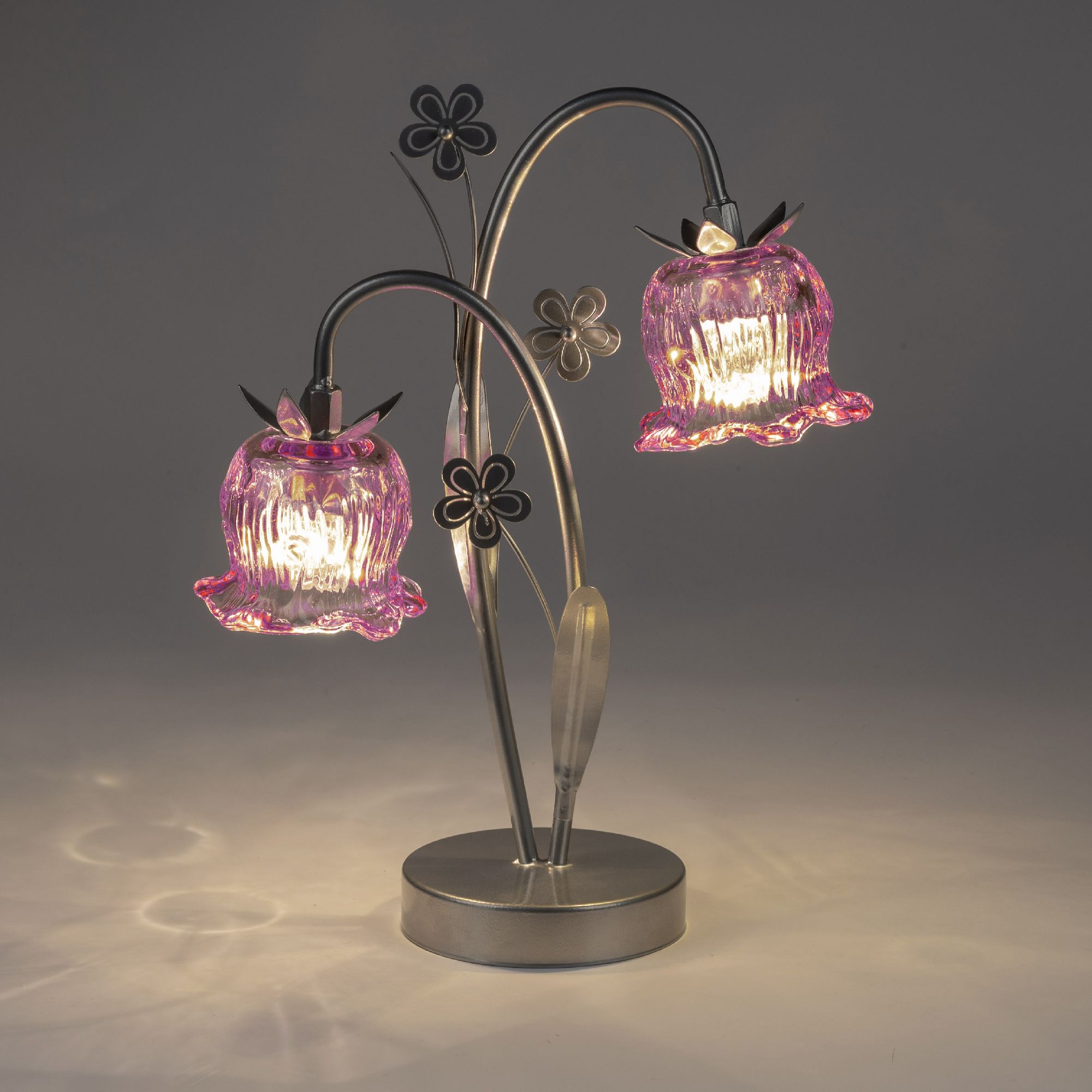 Tischlampe mit zwei blütenförmigen, pinken Glasschirmen und einem metallenen, geschwungenen Gestell.