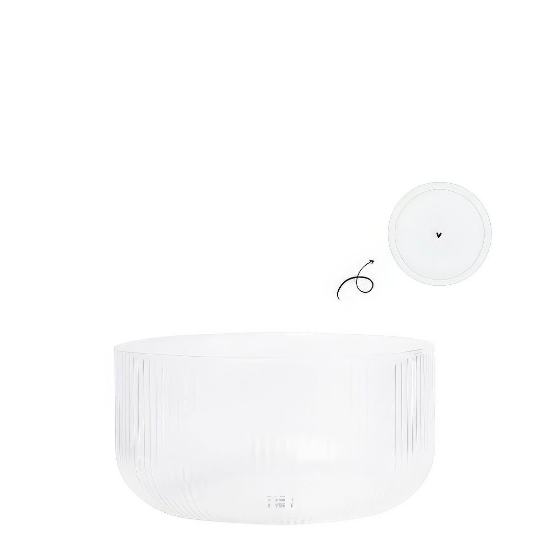 Transparente Schüssel mit gerillter Oberfläche und einem runden Deckel, der daneben liegt. Ein schwarzes Kabel ist sichtbar.