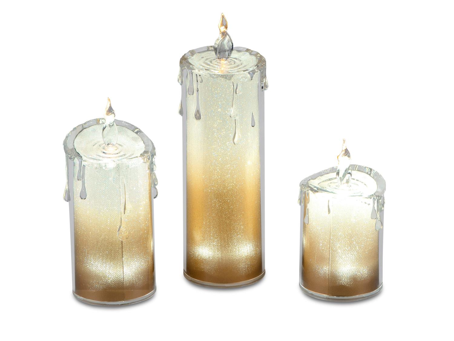 Drei Kerzen in verschiedenen Höhen mit glitzerndem, goldfarbenem Farbverlauf und tropfendem Wachs an den Rändern.
