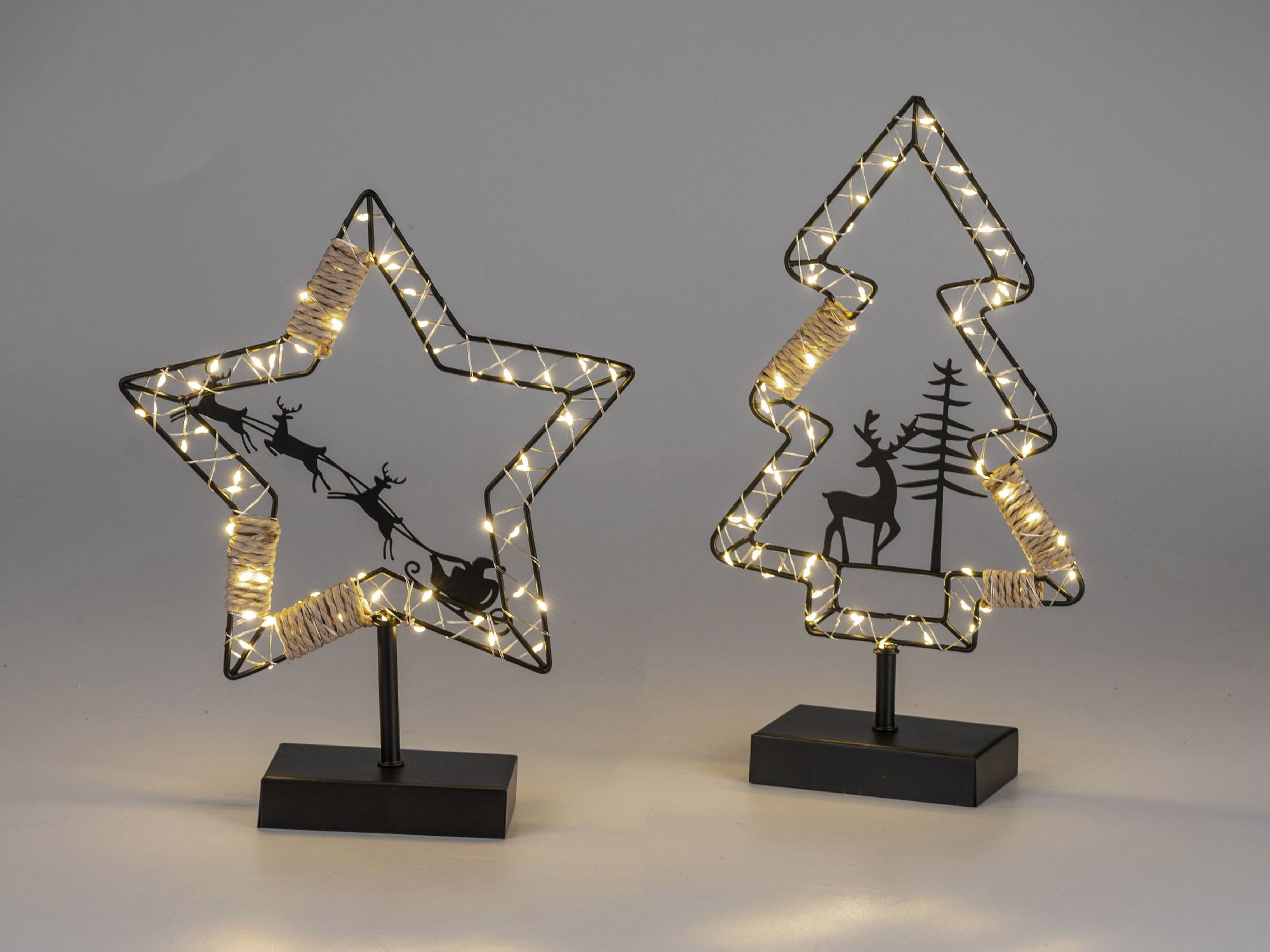 Zwei dekorative Figuren: ein Stern und ein Weihnachtsbaum, beide mit Lichtern und schwarzen Silhouet