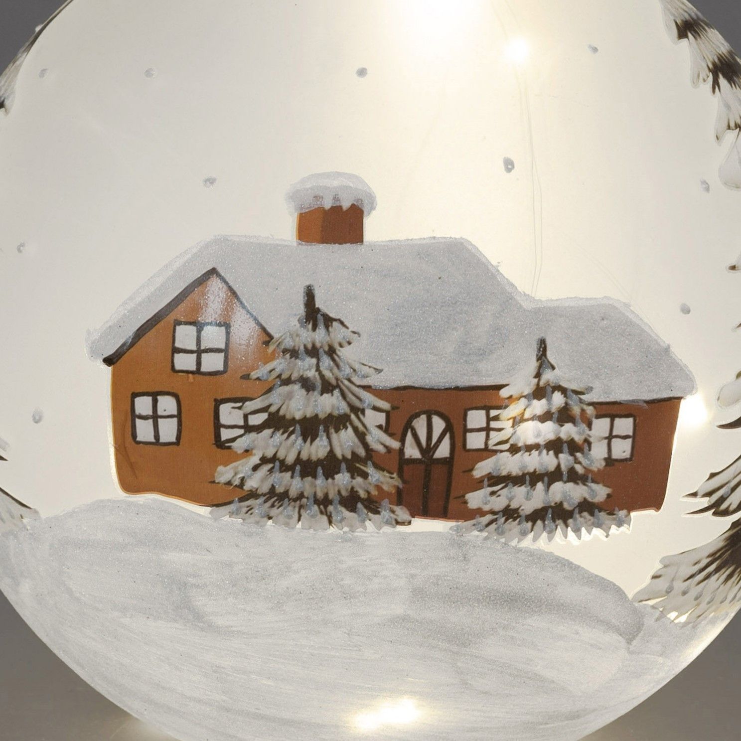 Eine winterliche Szene mit einem braunen Haus, umgeben von schneebedeckten Tannenbäumen und fallende