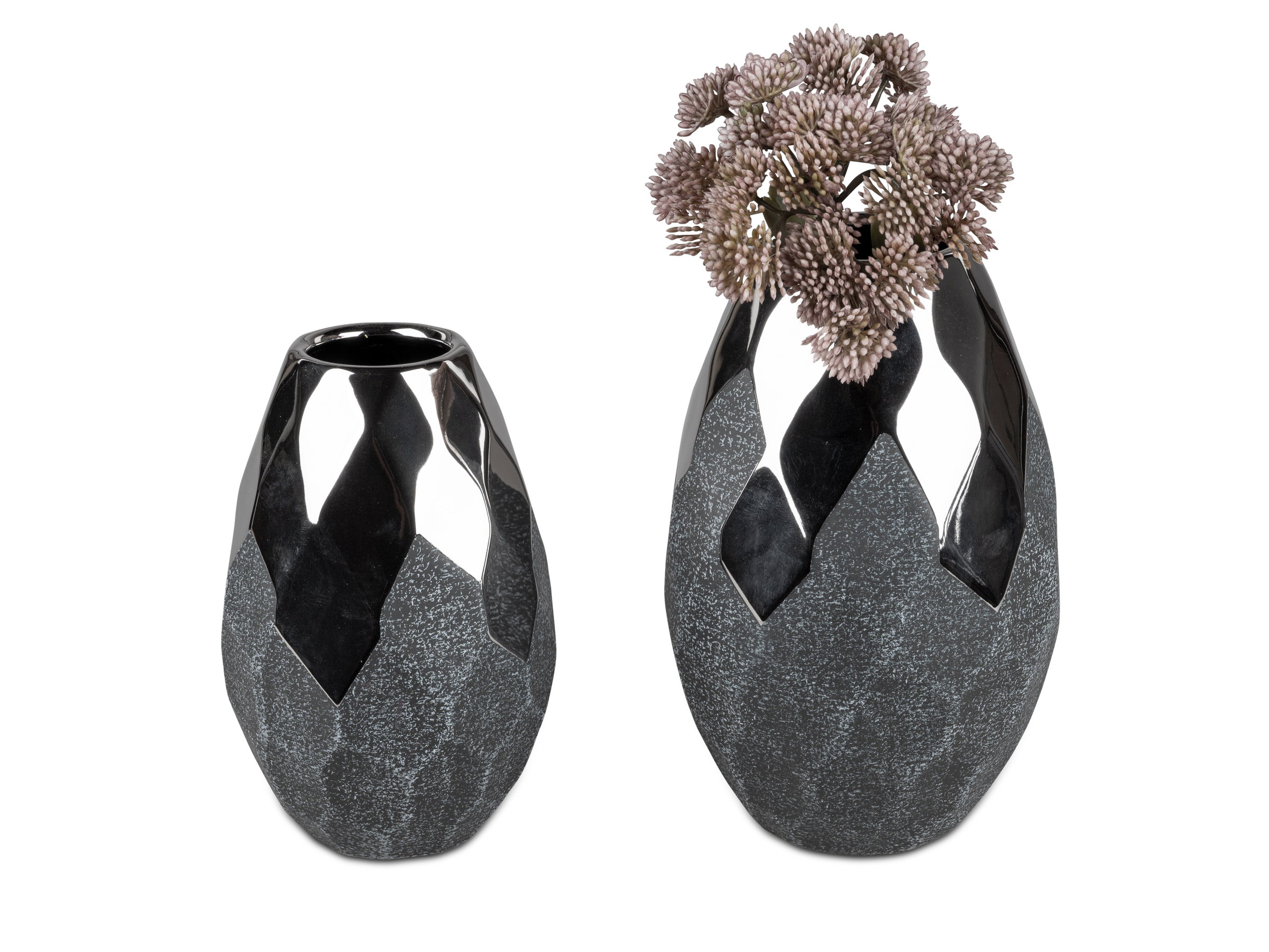 Zwei dekorative Vasen in Schwarz, eine mit Blumen, die andere ohne. Beide haben eine facettierte Obe