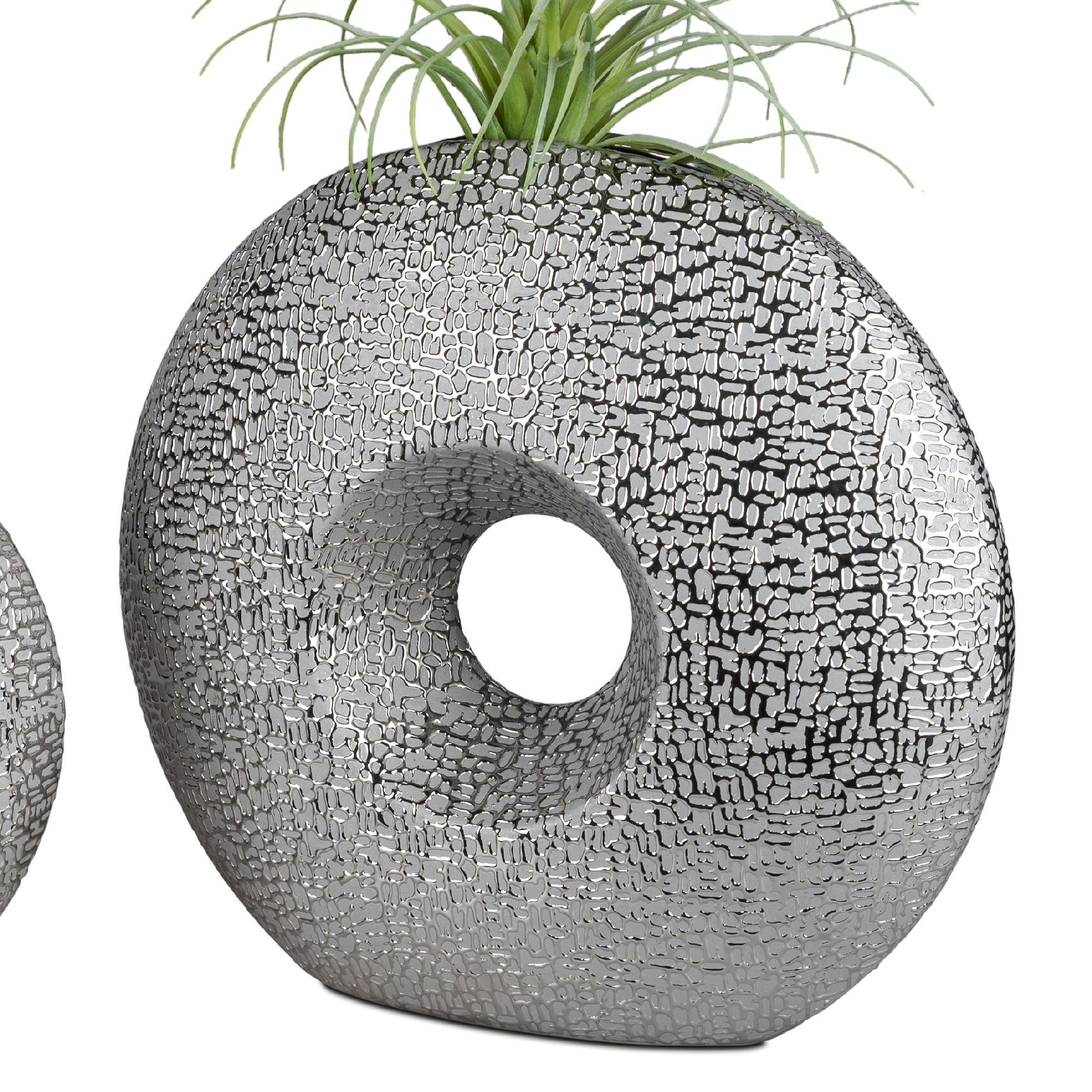 Zwei dekorative Vasen in runder Form mit einem Loch in der Mitte, verziert mit einem strukturierten, silbernen Muster.