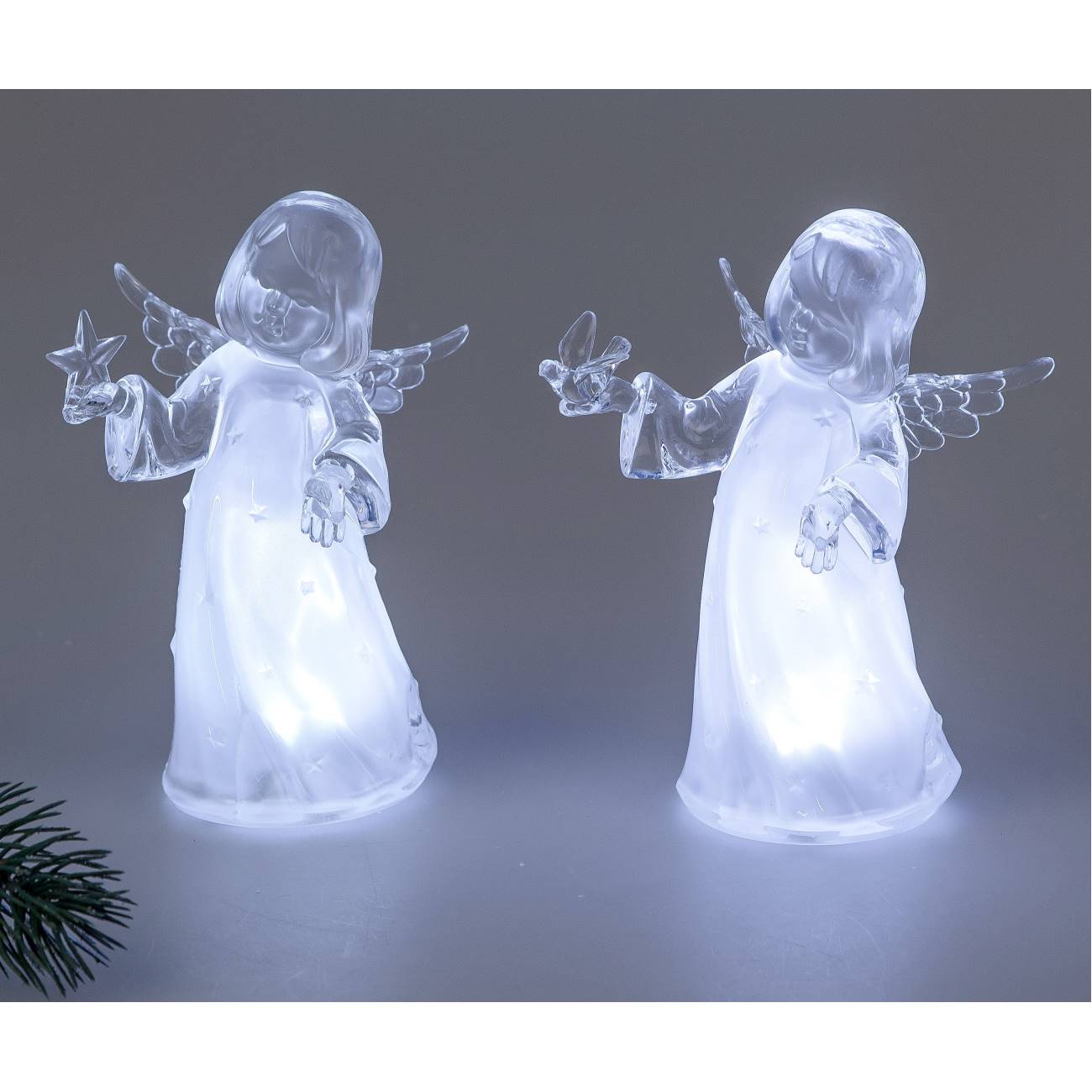 Zwei durchsichtige Engel-Figuren mit Flügeln, die jeweils einen Stern und einen Vogel halten, leucht