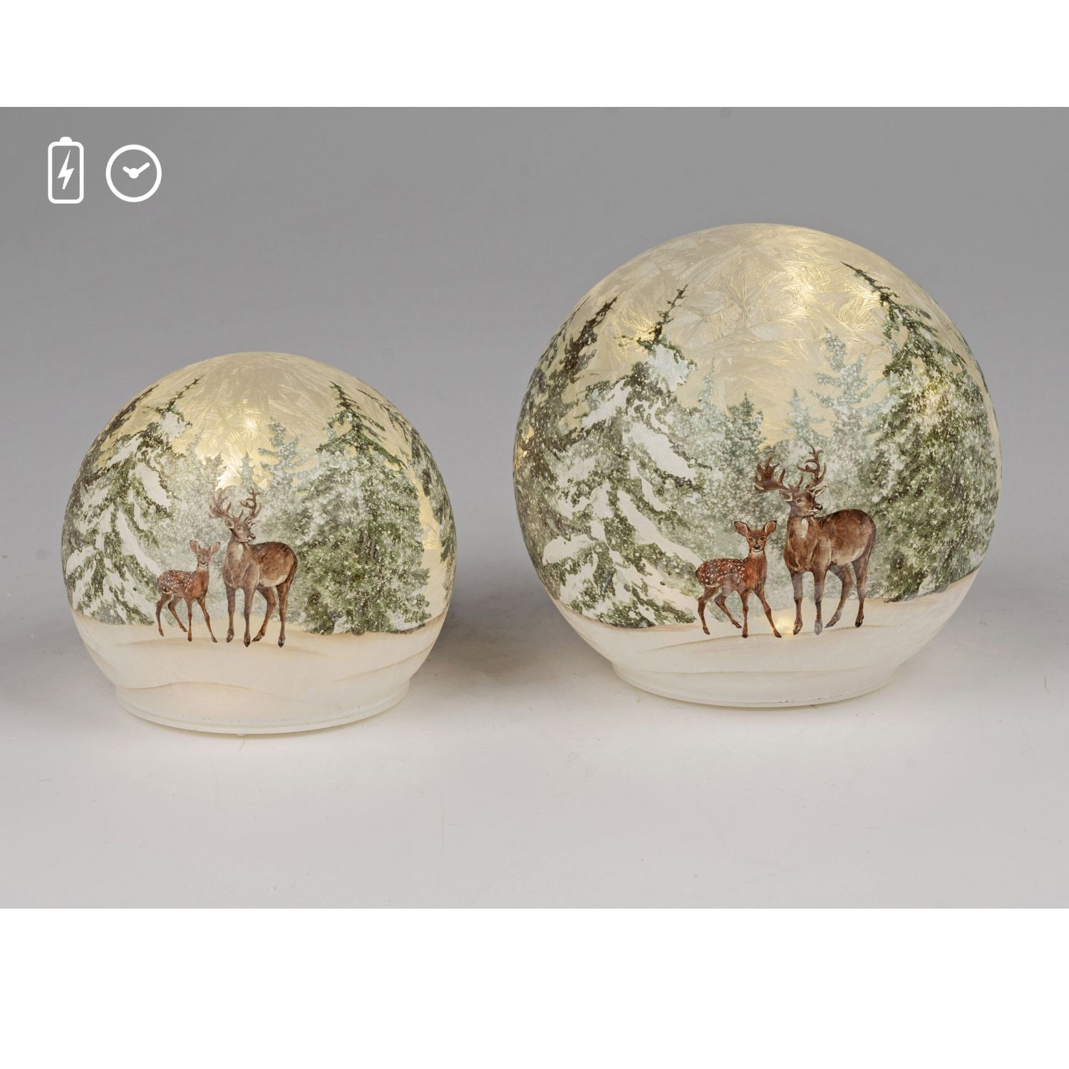 Zwei leuchtende Kugeln mit Winterwald und Hirschen auf heller Fläche