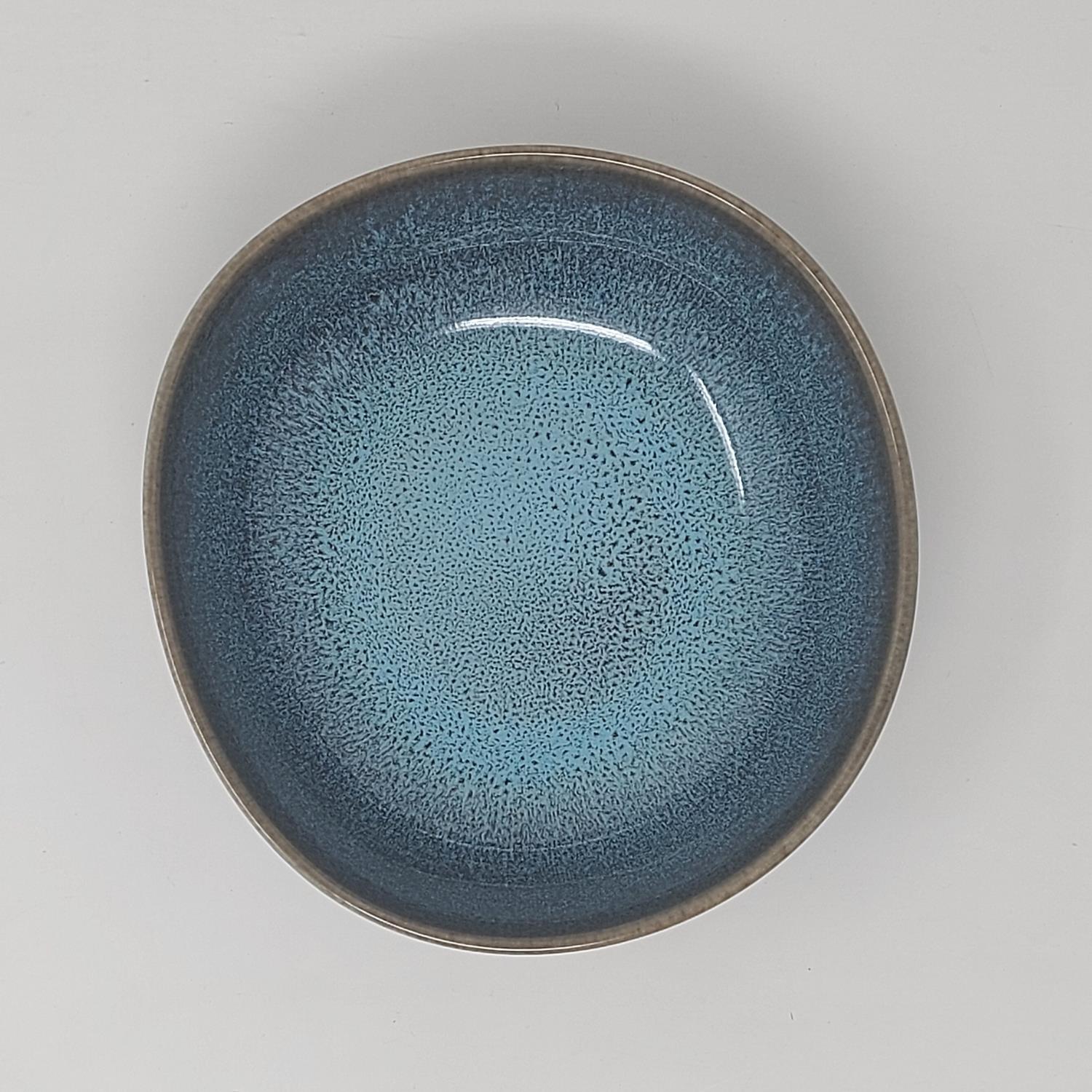 Runde Schale mit glatter, blauer Oberfläche und einem schmalen, grauen Rand. Die Innenseite zeigt ei
